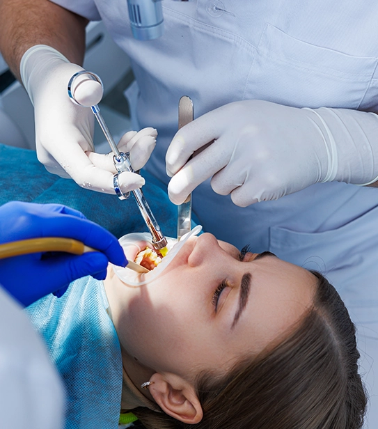 Dentist performing dental procedure using local anesthesia and modern equipment on patient